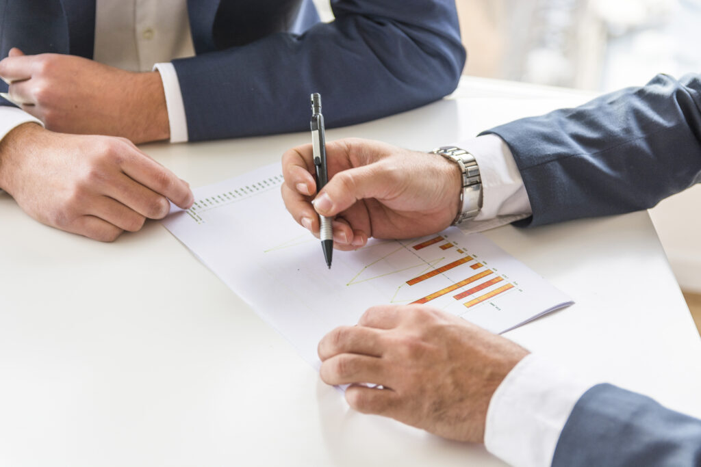 dwa-biznesmen-analizuje-biznesowego-raport-na-bialym-biurku
